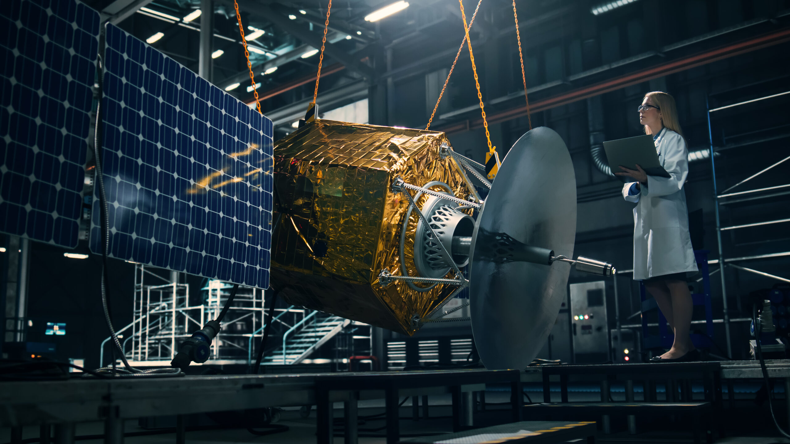 Industrial Engineer Working on Artificial Satellite Construction. Aerospace Agency: Female Scientist Using Laptop Computer to Develop Spacecraft for Space Exploration and Data Communication.